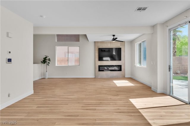 10613 Turquoise Valley Dr, Las Vegas, NV 89144 - unfurnished living room featuring baseboards, ceiling fan, visible vents, a fireplace, and light wood-type flooring