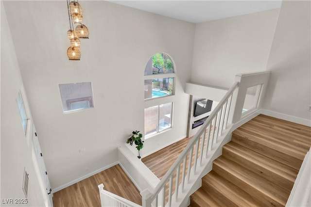 10613 Turquoise Valley Dr, Las Vegas, NV 89144 - stairway featuring wood finished floors, baseboards, and a high ceiling