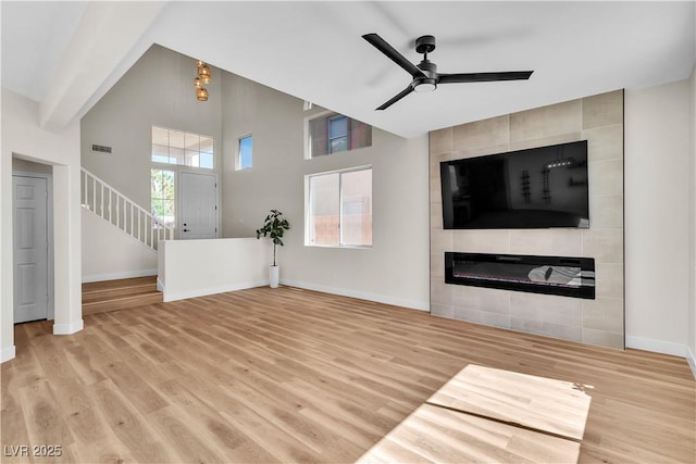 10613 Turquoise Valley Dr, Las Vegas, NV 89144 - unfurnished living room featuring wood finished floors, stairway, ceiling fan, a high ceiling, and baseboards