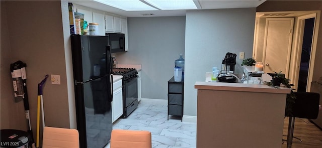 8070 W Russell Rd Unit 1105, Las Vegas, NV 89113 - kitchen featuring black appliances, marble finish floor, a breakfast bar area, a peninsula, and white cabinetry