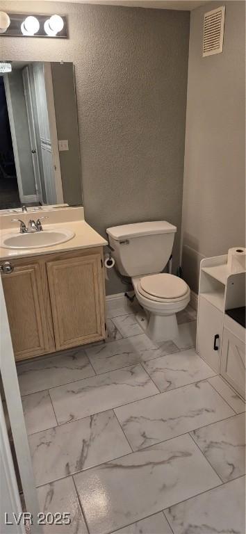 8070 W Russell Rd Unit 1105, Las Vegas, NV 89113 - bathroom with marble finish floor, toilet, a textured wall, vanity, and visible vents