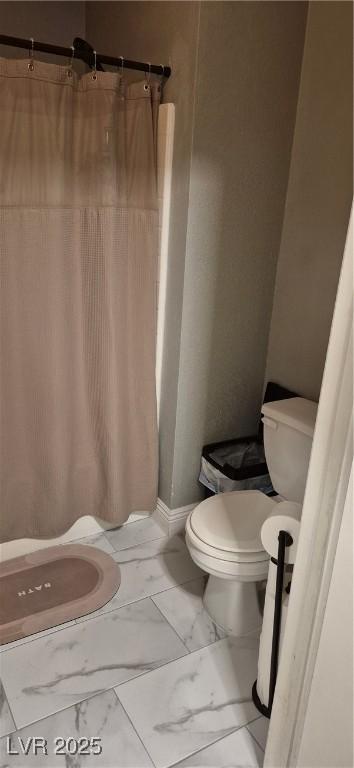 8070 W Russell Rd Unit 1105, Las Vegas, NV 89113 - bathroom featuring curtained shower, toilet, marble finish floor, and baseboards