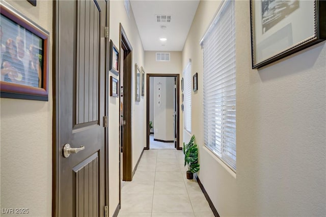 hallway featuring light tile patterned floors and visible vents