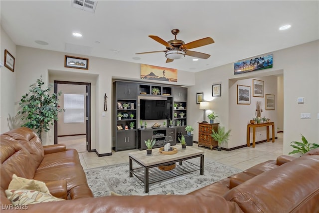 living area with baseboards, visible vents, light tile patterned floors, and ceiling fan