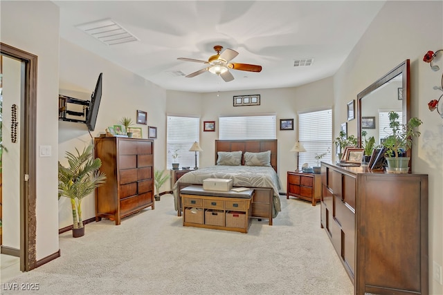 bedroom with multiple windows, light carpet, and visible vents