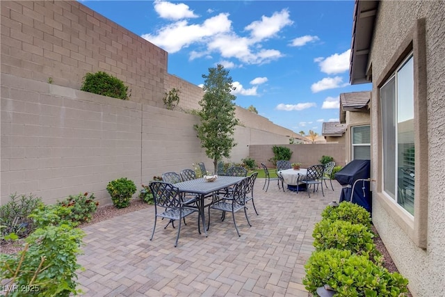 view of patio with a grill, outdoor dining area, and a fenced backyard