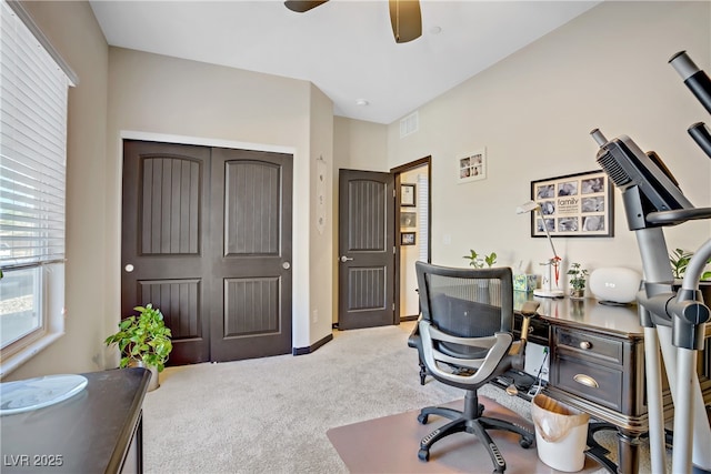 home office featuring light colored carpet, visible vents, and a ceiling fan