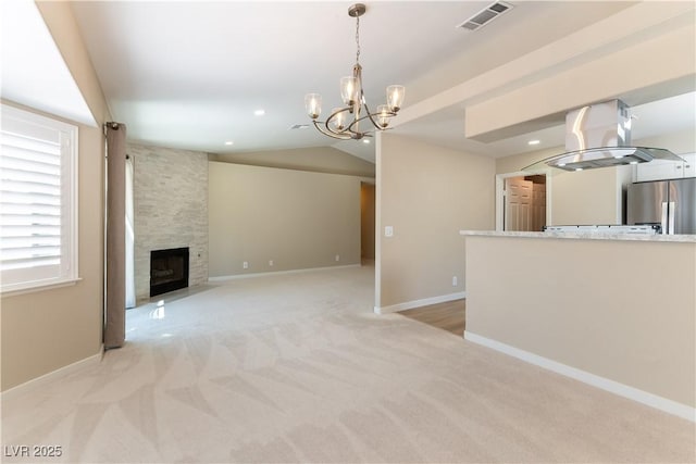5005 Chambliss Dr, Las Vegas, NV 89130 - unfurnished living room featuring light colored carpet, a chandelier, a large fireplace, baseboards, and vaulted ceiling