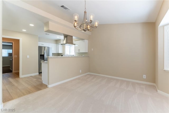 5005 Chambliss Dr, Las Vegas, NV 89130 - kitchen featuring wall chimney range hood, a chandelier, white cabinets, stainless steel refrigerator with ice dispenser, and light countertops