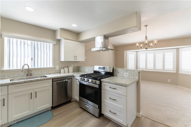 5005 Chambliss Dr, Las Vegas, NV 89130 - kitchen featuring appliances with stainless steel finishes, wall chimney exhaust hood, a sink, a peninsula, and a chandelier