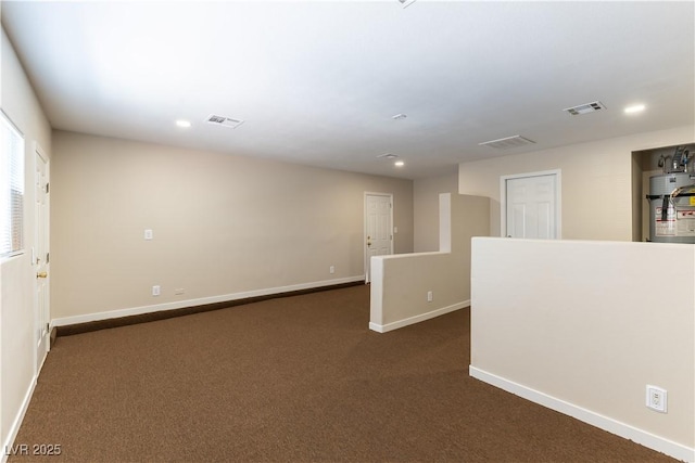 5005 Chambliss Dr, Las Vegas, NV 89130 - spare room with secured water heater, dark carpet, baseboards, and recessed lighting