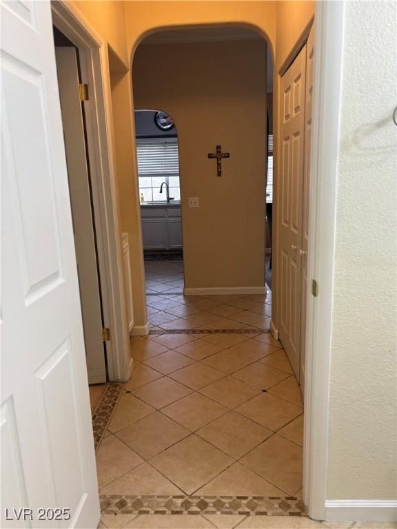 1851 Hillpointe Rd Unit 2621, Henderson, NV 89074 - corridor featuring a sink, arched walkways, baseboards, and light tile patterned flooring