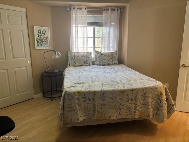bedroom featuring baseboards and light wood-style flooring