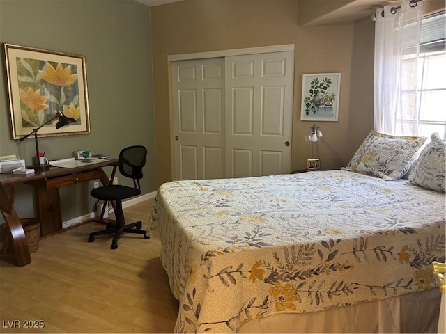 bedroom with baseboards, light wood finished floors, and a closet