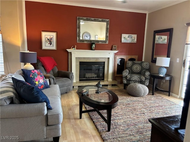 living area with a premium fireplace, crown molding, and light wood-style flooring