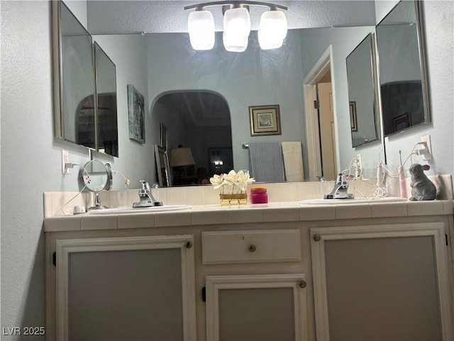 full bathroom featuring double vanity and a sink