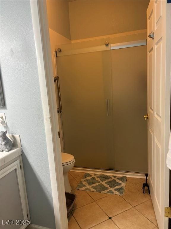 bathroom with tile patterned floors, toilet, vanity, and a shower stall