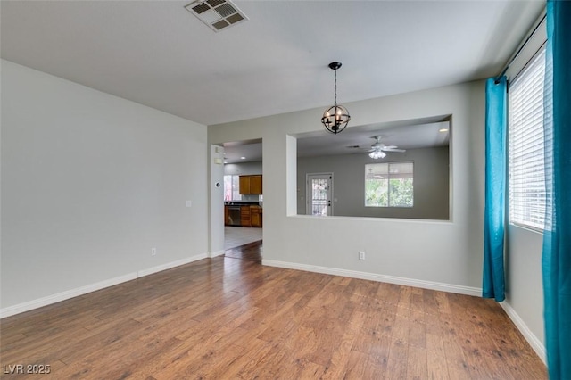 1048 Painted Daisy Ave, Henderson, NV 89074 - unfurnished living room with wood finished floors, ceiling fan, and a chandelier