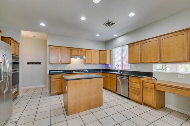 1048 Painted Daisy Ave, Henderson, NV 89074 - kitchen with appliances with stainless steel finishes, a kitchen island, recessed lighting, light tile patterned flooring, and under cabinet range hood
