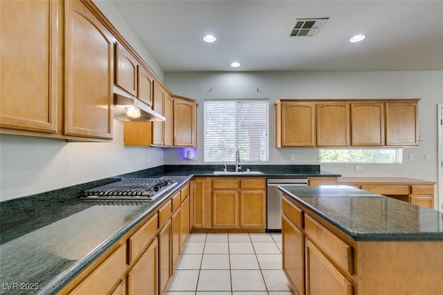 1048 Painted Daisy Ave, Henderson, NV 89074 - kitchen with stainless steel appliances, recessed lighting, dark stone countertops, a center island, and light tile patterned floors