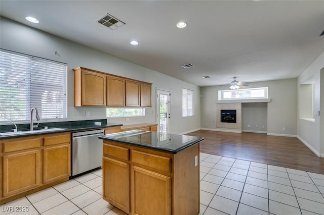 1048 Painted Daisy Ave, Henderson, NV 89074 - kitchen featuring dishwasher, light tile patterned floors, a fireplace, a center island, and a ceiling fan