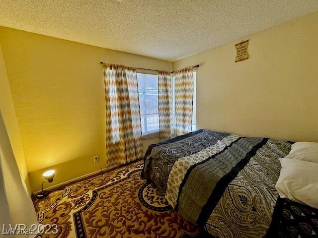 carpeted bedroom with a textured ceiling