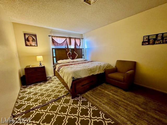 bedroom with a textured ceiling and baseboards