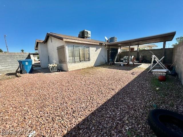 rear view of property with a fenced backyard, central AC unit, and a patio area