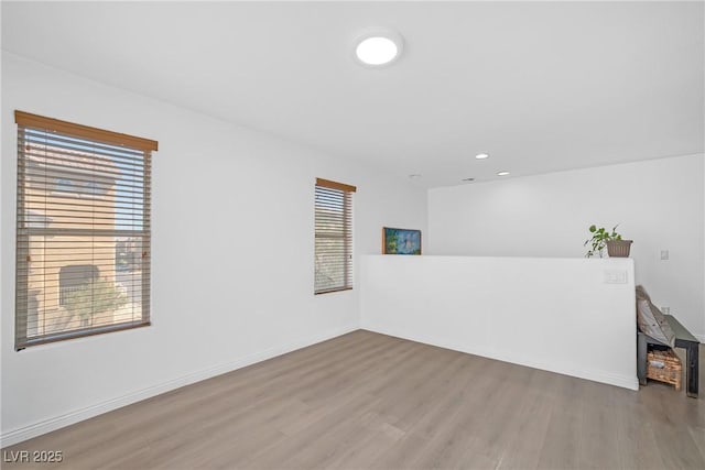 spare room with baseboards, recessed lighting, and wood finished floors