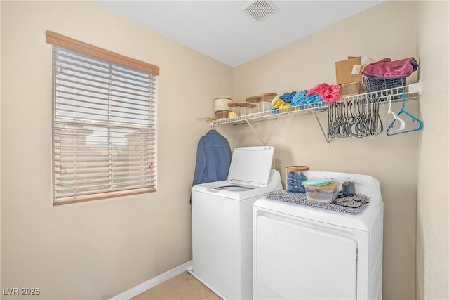 laundry area featuring visible vents, washing machine and clothes dryer, laundry area, and baseboards