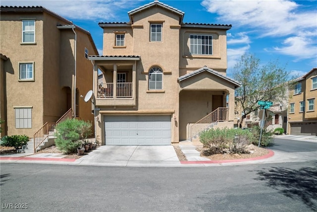 view of front of property featuring stairs, stucco siding, driveway, and a tiled roof