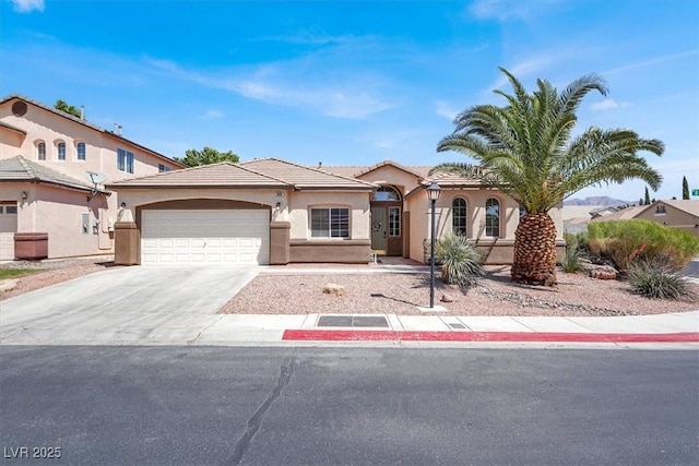 mediterranean / spanish-style house with driveway, a tile roof, stucco siding, and a garage