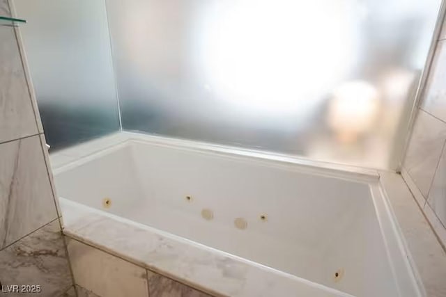 bathroom with a tub with jets