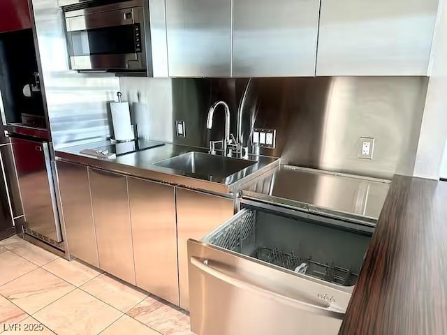kitchen with stainless steel microwave, modern cabinets, a sink, light tile patterned floors, and black electric stovetop