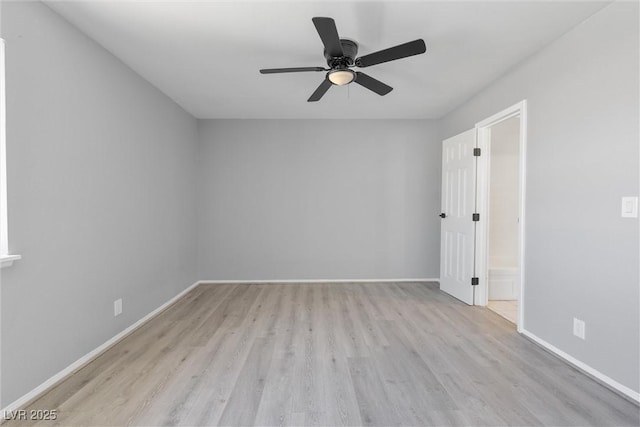 spare room featuring a ceiling fan, light wood-style flooring, and baseboards
