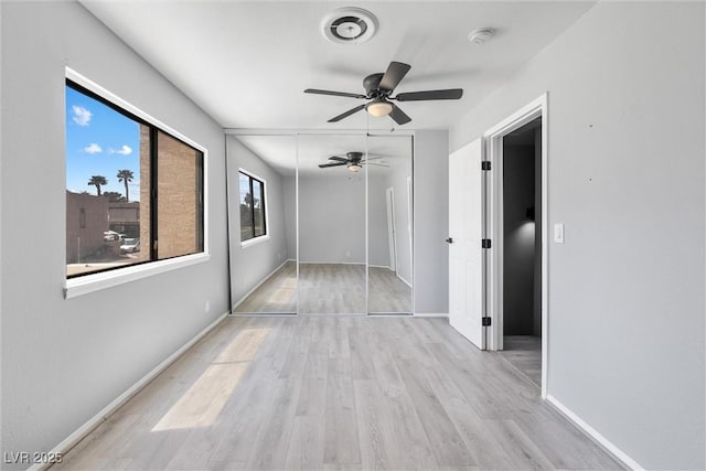 spare room featuring baseboards, wood finished floors, and a ceiling fan