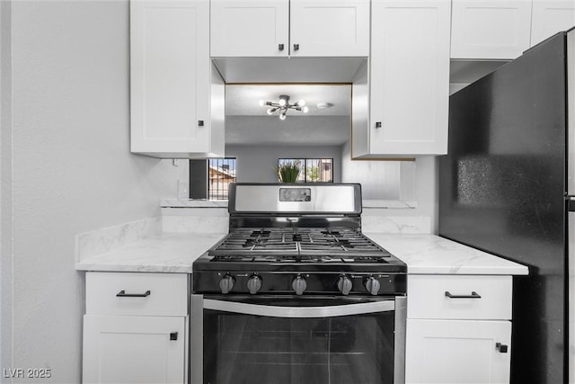 kitchen with white cabinets, stainless steel appliances, and light stone countertops