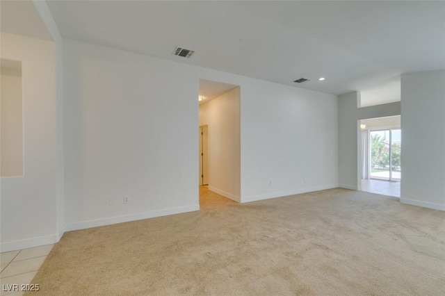 spare room featuring visible vents and light carpet