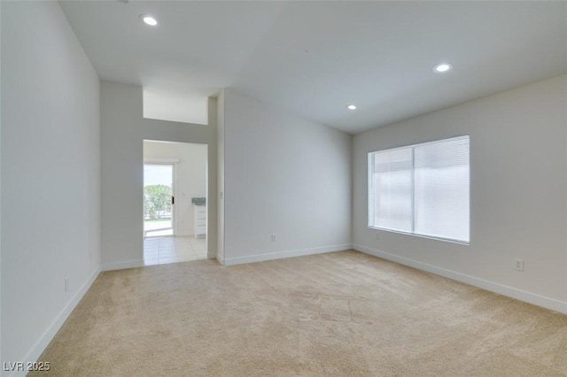 spare room with recessed lighting, light carpet, and baseboards
