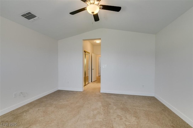 spare room with lofted ceiling, visible vents, ceiling fan, and light colored carpet