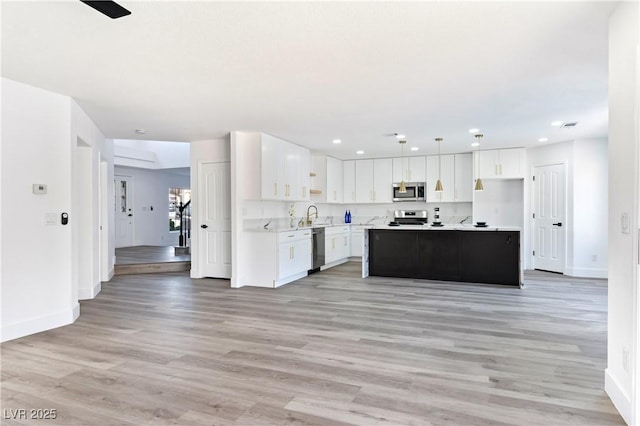 kitchen with white cabinetry, baseboards, appliances with stainless steel finishes, and light countertops
