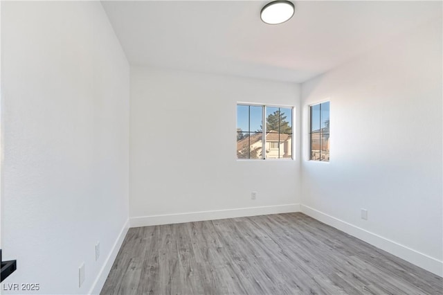 spare room with wood finished floors and baseboards