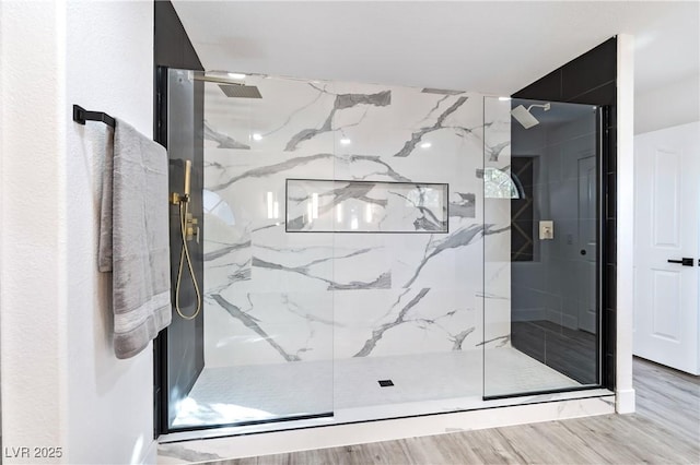 bathroom featuring wood finished floors and a marble finish shower