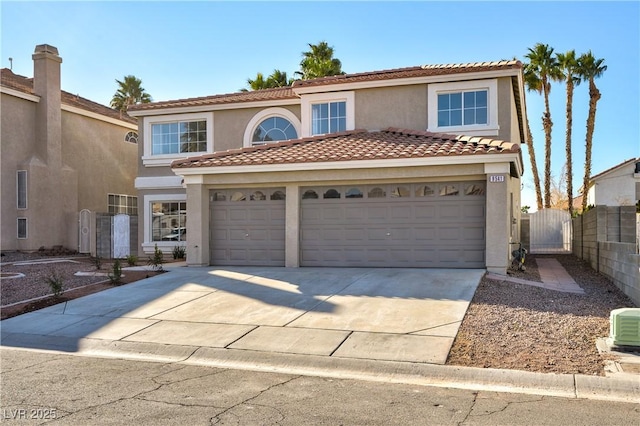 view of front of house featuring stucco siding, a gate, fence, driveway, and an attached garage