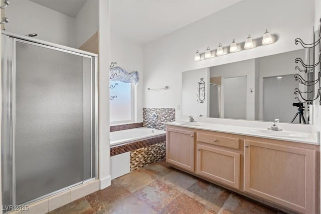 bathroom with double vanity, a sink, a bath, and a stall shower