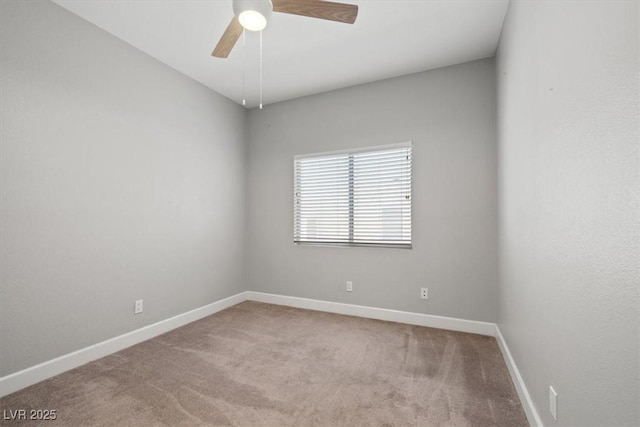 carpeted spare room featuring ceiling fan and baseboards