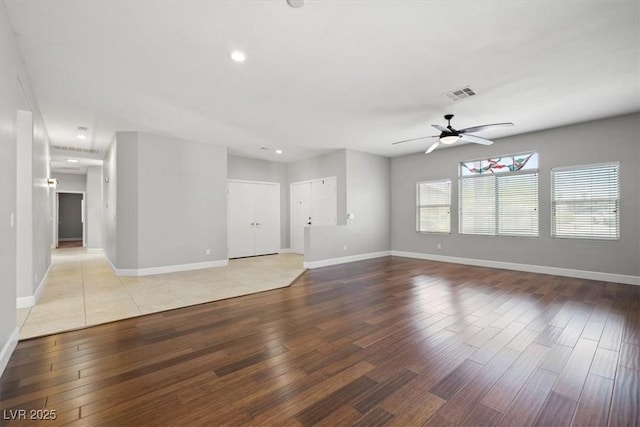 unfurnished living room featuring baseboards, a ceiling fan, wood finished floors, and visible vents