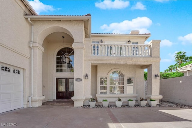 2595 Aviv Ct, Las Vegas, NV 89121 - view of exterior entry featuring concrete driveway, a balcony, stucco siding, french doors, and a garage