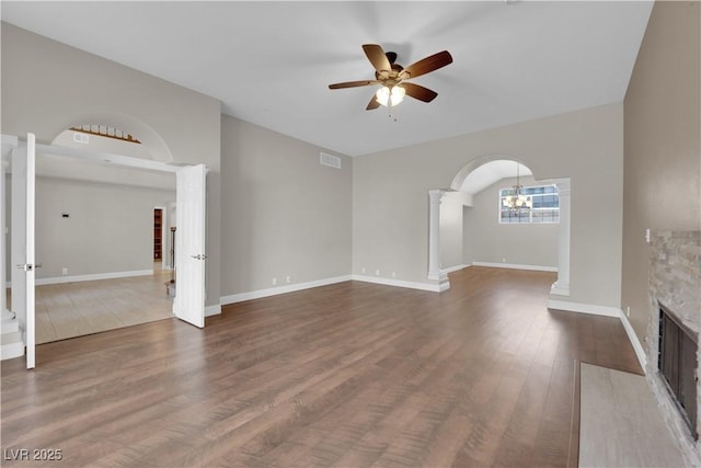 2595 Aviv Ct, Las Vegas, NV 89121 - unfurnished living room with a fireplace with flush hearth, ceiling fan, dark wood-style floors, arched walkways, and ornate columns