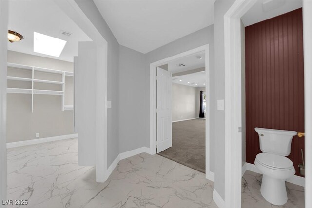 2595 Aviv Ct, Las Vegas, NV 89121 - bathroom with toilet, marble finish floor, a skylight, and baseboards